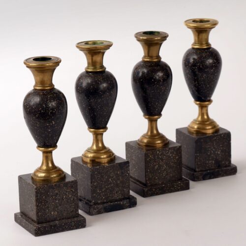 Four candlesticks made of brass and Blyberg porphyry